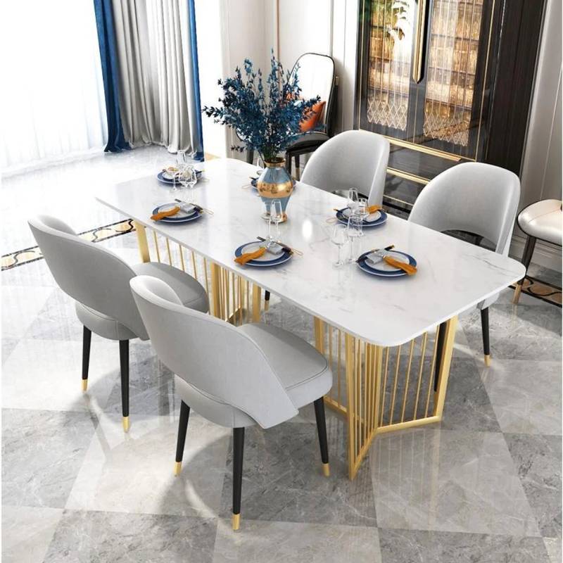 A modern dining room setup featuring a rectangular white marble-patterned table with a gold metal frame and six light gray upholstered chairs.