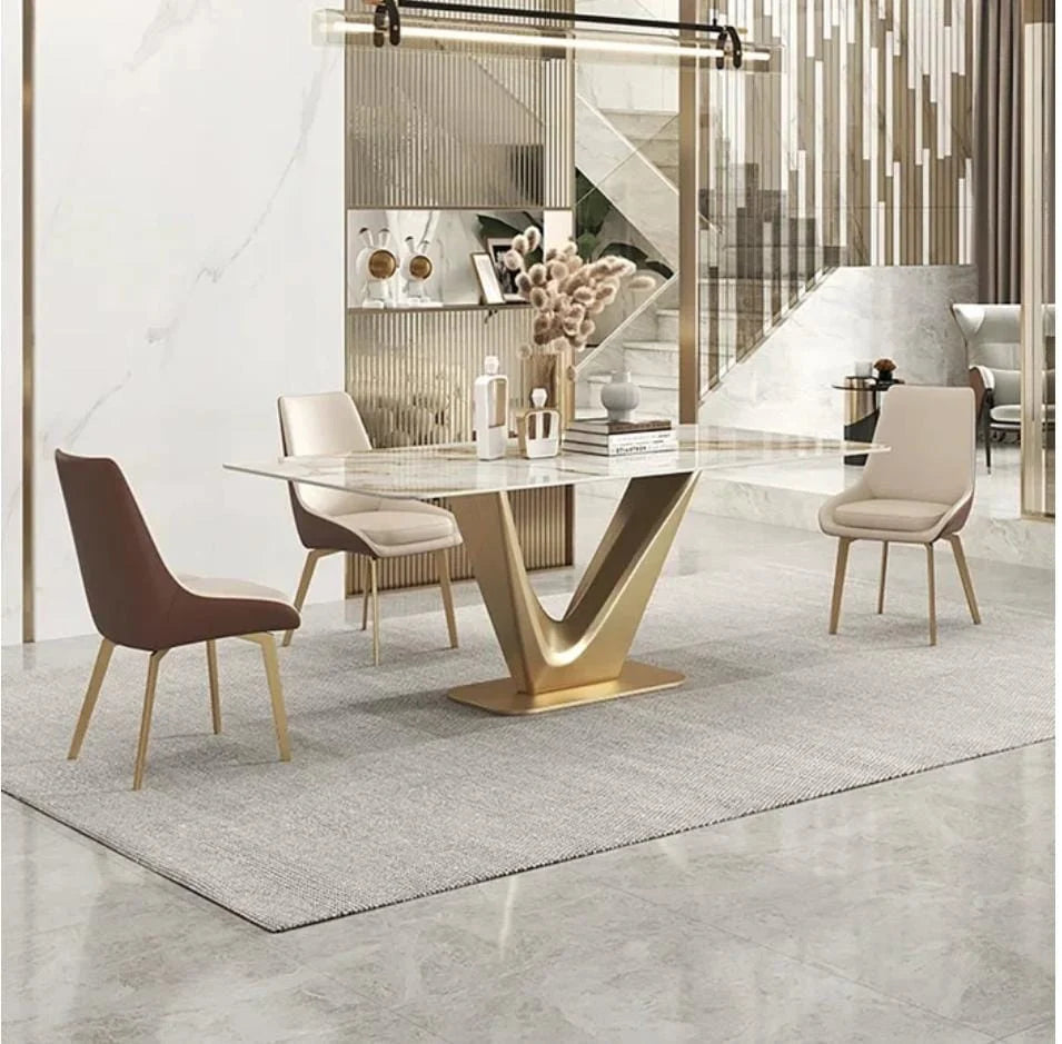 The-V Modern marble dining table with a gold base and three chair styles