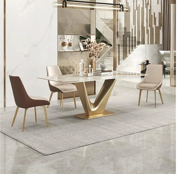 The-V Modern marble dining table with a gold base and three chair styles