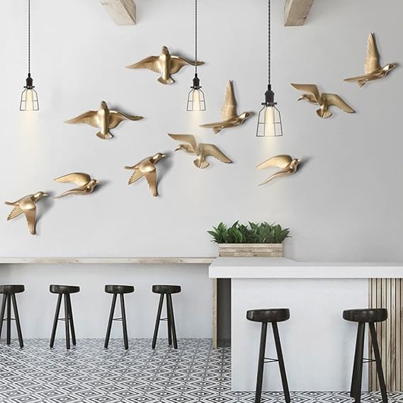 Golden seagull birds metal wall art arranged above a sofa