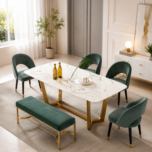 A modern dining set in a bright, elegant room, featuring a rectangular white marble-top table with gold legs, four dark green velvet chairs, and a matching green velvet bench with gold legs.